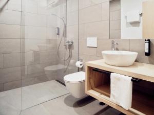 QuartenHotel Neu-Schönstatt的浴室配有卫生间、盥洗盆和淋浴。