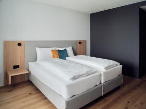 QuartenHotel Neu-Schönstatt的卧室配有带枕头的大型白色床