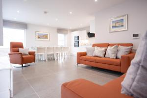 斯图尔特港Sea Breeze的一间带两张橙色沙发的客厅和一间厨房