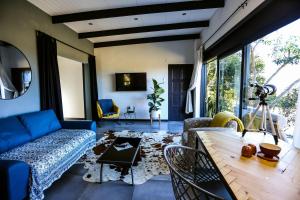 Haga-HagaHadada Self Catering Studio的客厅配有蓝色的沙发和桌子