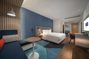 宜兴宜兴智选假日酒店的酒店客房配有一张床铺和一张桌子。