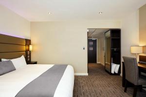 哈德斯菲尔德Fortune Huddersfield; Sure Hotel Collection by Best Western的酒店客房设有一张大床和一张书桌。