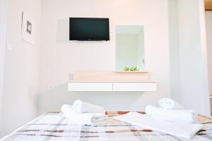 奥马斯帕纳吉亚斯伊万吉丽娅的家庭旅馆的白色客房 - 带毛巾和一台电视