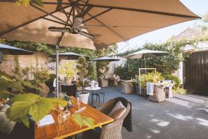 迪温特Grand Boutique Hotel-Restaurant Huis Vermeer的一个带桌椅和遮阳伞的庭院