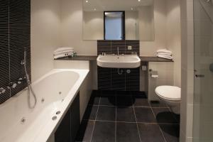里德凯尔克凡德瓦克酒店的带浴缸、盥洗盆和卫生间的浴室