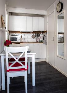 维斯比卡尔奥斯卡尔斯克莱宾公寓的厨房配有白色桌子和红色椅子