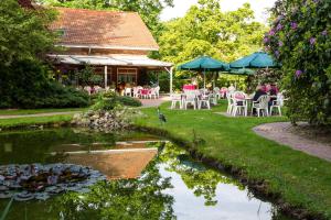 Loxstedt巴斯曼旅馆的一个带桌椅的花园和一个池塘