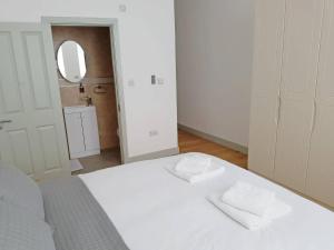 伦敦Forest House Hotel的卧室配有白色的床和2条毛巾