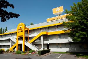 阿尔勒阿尔勒普瑞米尔经典酒店的上面有标志的黄色和白色建筑