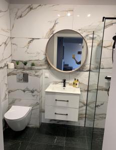比亚瓦波德拉斯卡Apartament Luna的一间带水槽、镜子和卫生间的浴室