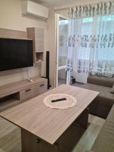 鲁塞ЗАРА的客厅配有桌子和平面电视。