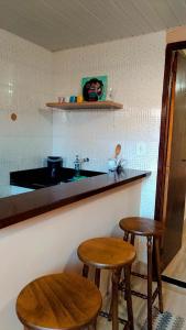 特雷索波利斯Hospedagem Doce Lar - Casa Girassol的厨房配有2张凳子和带水槽的台面