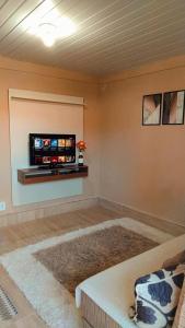 特雷索波利斯Hospedagem Doce Lar - Casa Girassol的客厅设有壁挂式平面电视。