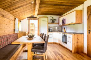 圣科罗曼Bio-Familienbauernhof Grubsteighof的厨房配有木桌和椅子