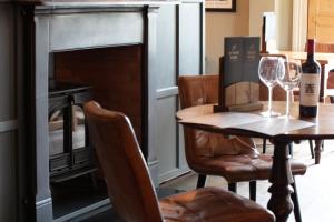 埃文河畔斯特拉特福Broom Hall Inn的一间带桌子和壁炉的用餐室