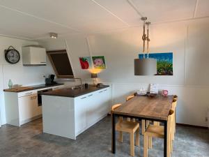 比伦Waddenresidentie Ameland Nummer vier的一间带桌子的厨房和一间餐厅