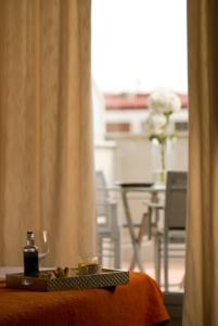 马德里别纳西班牙广场套房酒店的一间设有桌子、一瓶酒和一个窗户的客房