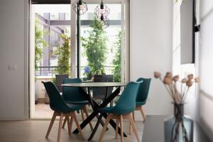 罗马斯卡尔兹公寓的一间带桌子和绿色椅子的用餐室