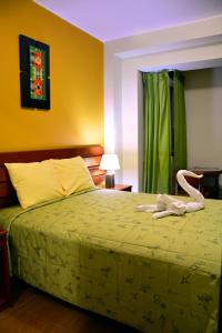 纳斯卡索尔德尔苏尔酒店的一间卧室配有一张带绿床罩的床