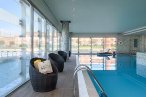 阿威罗利雅Spa美利亚酒店的大堂设有游泳池、椅子和窗户