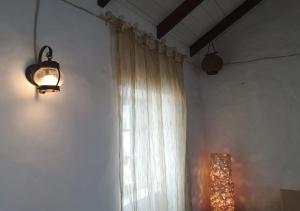 CabeçadasNos Kasa Povoaçao Velha的一间设有窗帘、窗户和灯的房间