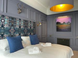 爱丁堡Ben Cruachan Guest House的卧室配有带蓝色枕头的大型白色床
