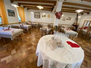 Artegna阿尔城堡酒店的用餐室配有带白色桌布的桌子