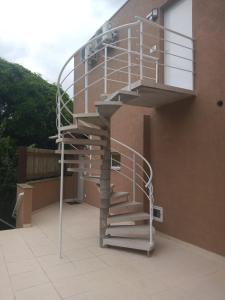 伊利亚贝拉Ilhabela Beach Residences的建筑物一侧的金属螺旋楼梯