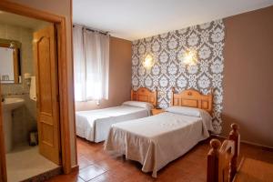 圣伊西德罗Hotel La Braña的一间带两张床的卧室和一间带水槽的浴室