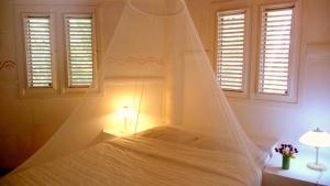 里奥圣胡安Las Puertas del Paraíso的卧室配有带蚊帐的白色床