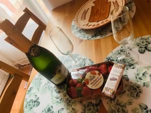 滨海比拉萨尔CASA la PAU的一瓶葡萄酒和一盒草莓放在桌子上