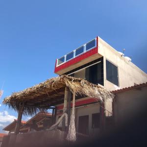 加利纽斯Pousada O Mineiro - frente a praia的一座带茅草屋顶的建筑