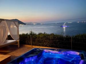 梅松吉Palms and Spas Villas Retreat的阳台设有蓝色浴缸,享有水景