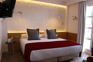 科尔多瓦流苏精品酒店的一间卧室配有一张带红色毯子的大床