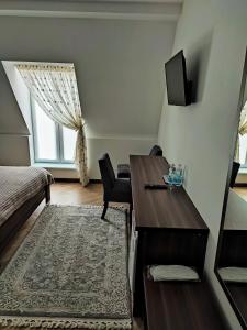 别列戈沃Готель-ресторан "Олеся"的一间卧室配有书桌、床和窗户。