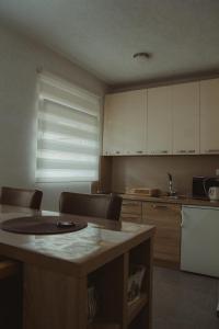 普卢日内Apartment Silence的厨房配有白色橱柜和桌子