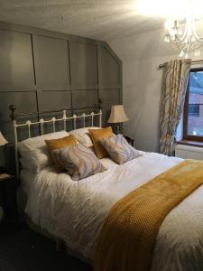 East Harling榆树酒店的一间卧室配有一张大床和大床头板