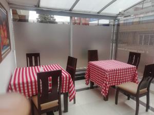 波哥大Embassy On Holidays的两张桌子和椅子,配有红白桌布