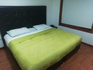 波哥大Embassy On Holidays的一间卧室配有一张带绿毯的床