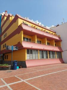 大加那利岛拉斯帕尔马斯梅普康缇瑞斯公寓酒店的前面有路标的黄色和红色建筑