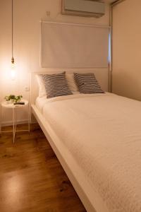 埃拉特Eilat vacation house דירות נופש אילת的一张带两个枕头和一张桌子的白色床
