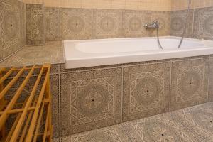 埃拉特Eilat vacation house דירות נופש אילת的带浴缸和瓷砖墙的浴室