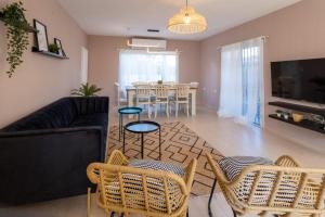 埃拉特Eilat vacation house דירות נופש אילת的客厅配有沙发、椅子和桌子