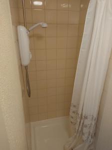 布莱克浦Fernlea Hotel的浴室内带电话的淋浴