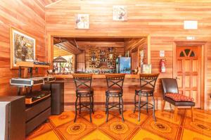Teakettle VillageDream Valley Belize的一间酒吧,位于一间设有木墙和酒吧凳子的房间