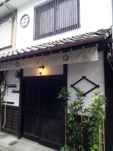 京都Kyoto Villa Fuka的一座有黑色大门和墙上一个时钟的房子