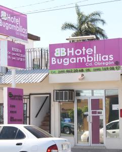 奥夫雷贡城Hotel Bugambilias的停在大楼前的白色汽车