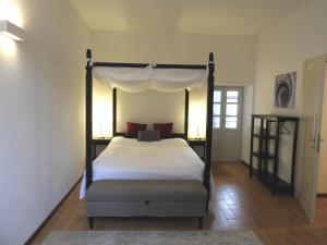 勒威诺Villa Maghetti - modernized flat in historic palazzo in the center of Luino的一间卧室配有一张带天蓬的床