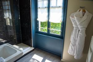 巴约讷Hôtel Villa la Renaissance的一间带水槽的浴室和一个带毛巾的窗户。