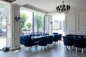 切尔诺夫策Grand Royal的一间配备有蓝色椅子和桌子的用餐室